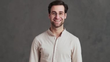 Gözlüklü gülümseyen bir adam stüdyoda evet derken zafere seviniyor.