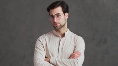 Düşünceli adam negatif başını sallıyor ve stüdyoda kollarını kavuşturarak hayır işareti yapıyor.