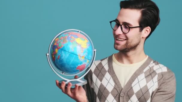 Portrét Muže Brýlemi Točícími Zeměkouli Modrém Studiu — Stock video