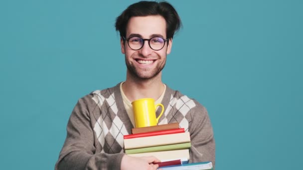 Lachende Man Een Bril Met Een Stapel Boeken Een Beker — Stockvideo