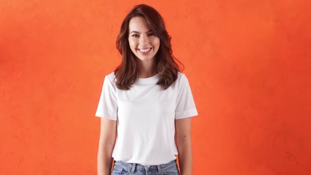 Usmívající Žena Ukazuje Pořádku Gesto Zatímco Stojí Oranžovém Studiu — Stock video