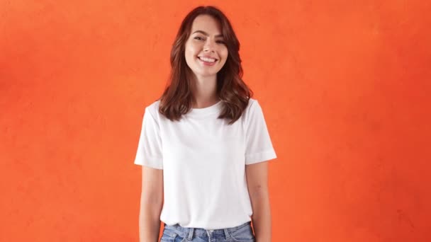 Χαμογελαστή Γυναίκα Που Στέκεται Στο Πορτοκαλί Στούντιο — Αρχείο Βίντεο