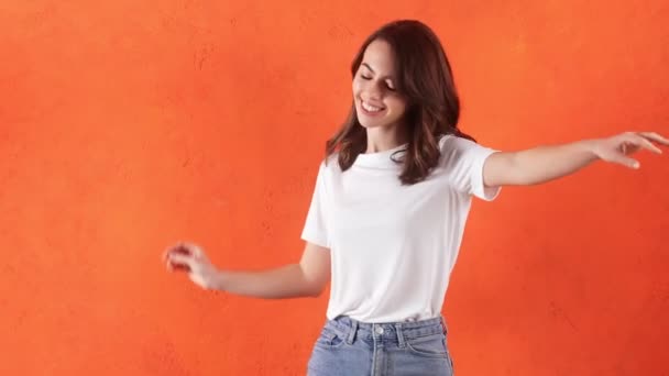 Улыбающаяся Женщина Танцует Оранжевой Студии — стоковое видео