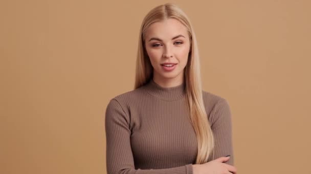 Şaşırmış Genç Sarışın Bir Kadın Kameraya Bakıyor Stüdyoda Bej Bir — Stok video