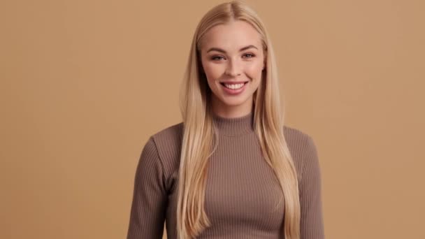 Счастливая Молодая Блондинка Показывает Жест Сторону Камеры Стоящей Изолированно Бежевом — стоковое видео