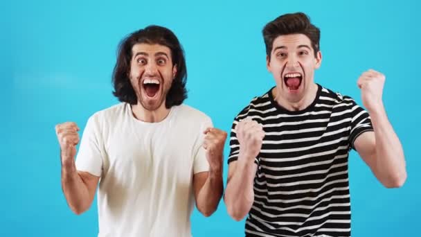 Dos Hombres Sonrientes Con Camisetas Regocijándose Por Victoria Mientras Están — Vídeos de Stock
