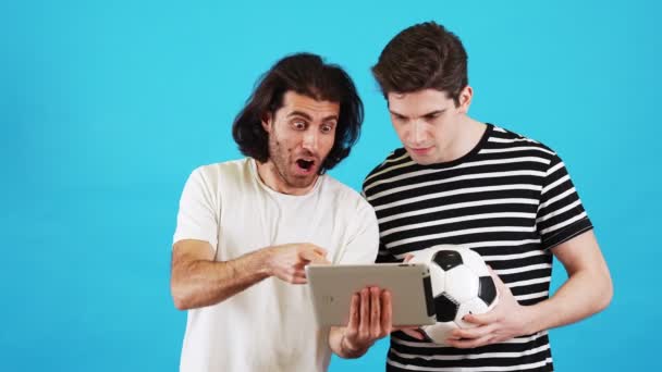 Dois Homens Assistindo Jogo Tablet Com Uma Bola Futebol Suas — Vídeo de Stock