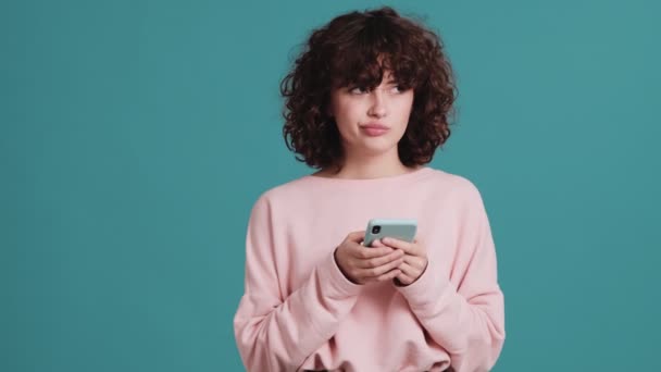 Düşünceli Kadın Yanıtı Düşünüyor Mavi Bir Stüdyoda Telefonla Yazıyor — Stok video