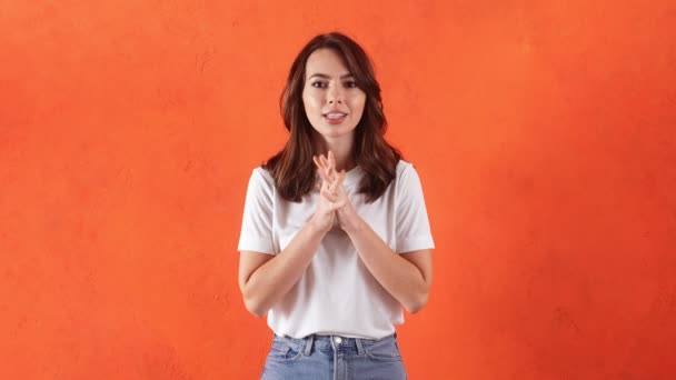 彼女の手で積極的にジェスチャーすることによって勝つと喜びを望んでいる女性オレンジスタジオ — ストック動画