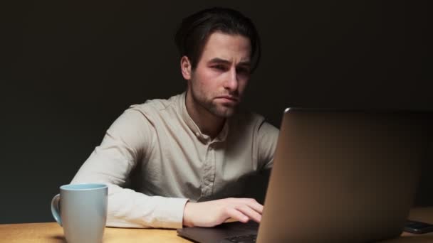 Een Geconcentreerde Man Werkt Met Zijn Laptop Terwijl Hij Nachts — Stockvideo