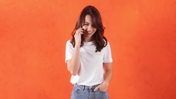 Smiling Woman Talking Phone Holding Hand Jeans Pocket Orange Studio — Video