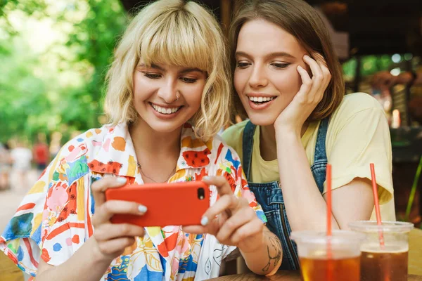Beeld Van Vrolijke Twee Vrouwen Glimlachend Met Behulp Van Mobiele — Stockfoto