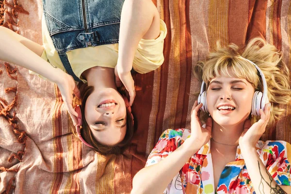 Imagen Dos Mujeres Felices Sonriendo Usando Auriculares Inalámbricos Mientras Están —  Fotos de Stock