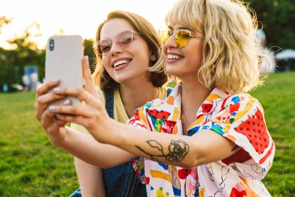 Bild Upphetsade Två Kvinnor Solglasögon Som Tar Selfie Smartphone Medan — Stockfoto