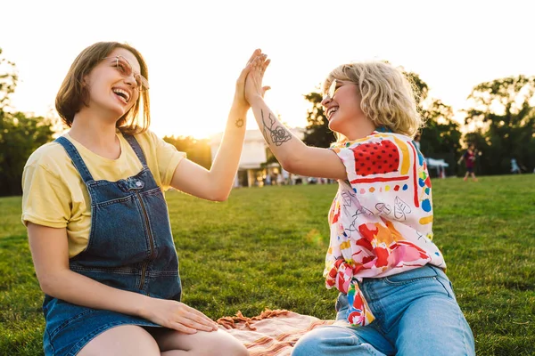 图片中 两个戴着太阳镜的女人在夏天的公园里笑着 高高兴兴地笑着 — 图库照片
