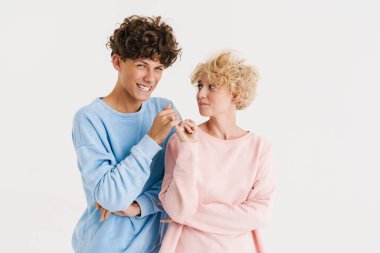 Beyaz arka planda izole edilmiş serçe parmağı tarafından oluşturulan genç, pozitif bir çiftin görüntüsü