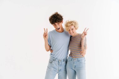 Mutlu, genç ve sevgi dolu bir çiftin beyaz arka planda izole edilmiş barış jestleri.