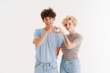 Genç ve mutlu bir çiftin beyaz arka planda izole edilmiş kalp hareketi görüntüsü.