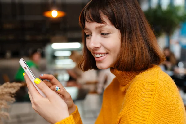 Boldog Vörös Hajú Lány Mosolyog Használja Mobiltelefon Miközben Kávézóban — Stock Fotó