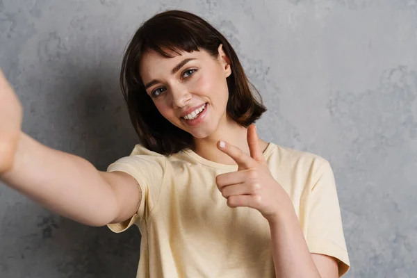 Sorrindo Jovem Tirando Uma Foto Selfie Smartphone Sobre Fundo Cinza — Fotografia de Stock