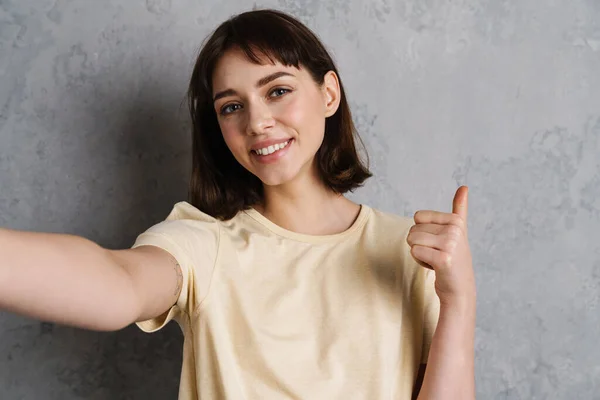 Sorrindo Jovem Tirando Uma Foto Selfie Smartphone Sobre Fundo Cinza — Fotografia de Stock