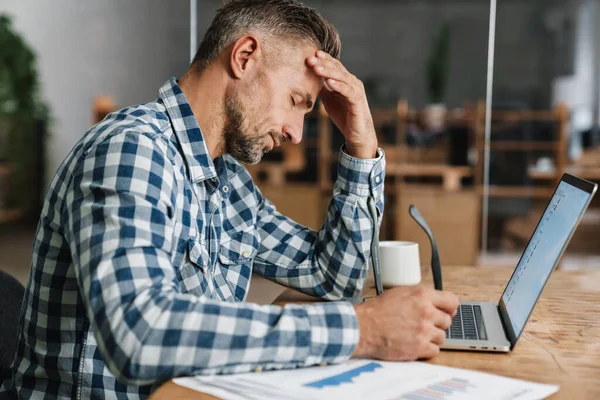 Hombre Gris Cansado Que Trabaja Con Ordenador Portátil Mientras Está —  Fotos de Stock
