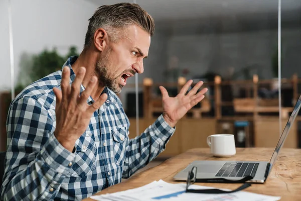 Furioso Uomo Grigio Urla Gesti Mentre Lavora Con Computer Portatile — Foto Stock