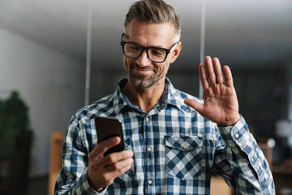 Feliz Hombre Pelo Blanco Agitando Mano Mientras Usa Teléfono Móvil — Foto de Stock