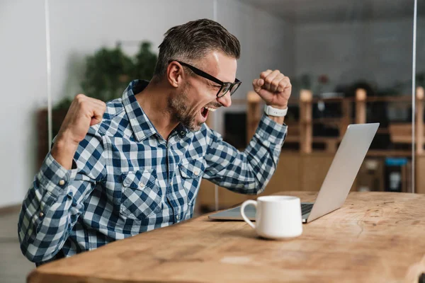 Spännande Man Skriker Och Gör Vinnaren Gest När Arbetar Med — Stockfoto