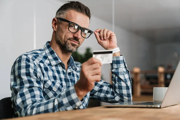 Fókuszált Borotválatlan Férfi Használja Hitelkártyát Miközben Dolgozik Laptop Irodában — Stock Fotó