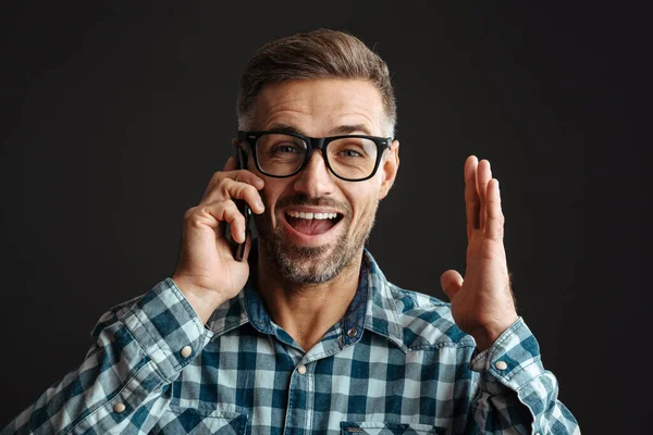 Knappe Opgewonden Man Bril Praten Mobiele Telefoon Geïsoleerd Zwarte Achtergrond — Stockfoto