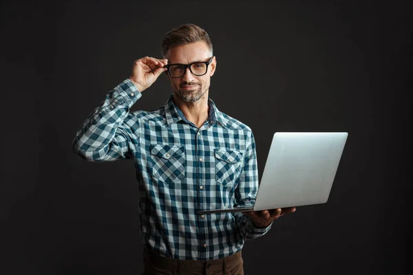 ノートパソコンを使って灰色の壁の背景に隔離された白髪の正の男のイメージ — ストック写真