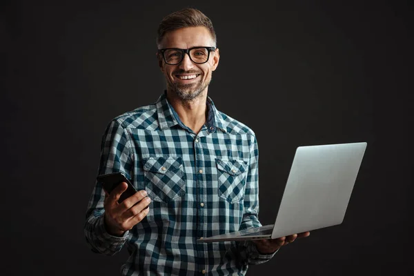 Sorrindo Homem Sem Barba Óculos Segurando Laptop Celular Isolado Sobre — Fotografia de Stock