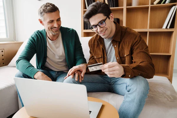 Feliz Jovem Gay Casal Usando Laptop Computador Enquanto Sentado Sofá — Fotografia de Stock