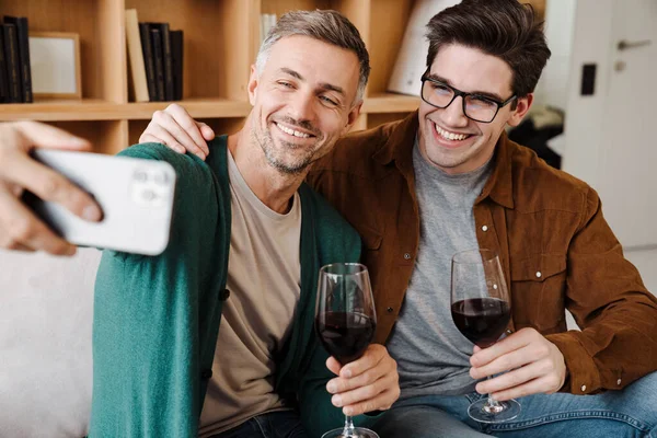 Glückliches Homosexuelles Paar Das Sich Umarmt Und Wein Trinkt Während — Stockfoto