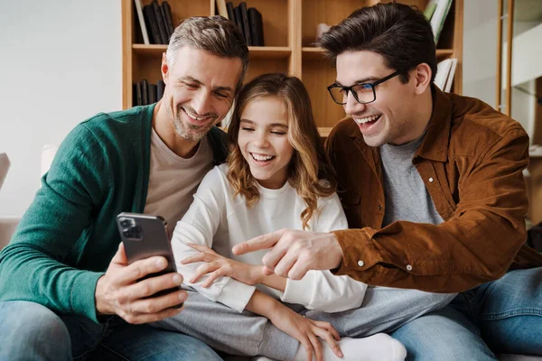 Happy Gay Family Smiling Using Mobile Phone While Sitting Couch — Stock Photo, Image