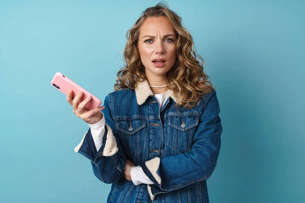Rubia Mujer Disgustada Usando Teléfono Móvil Frunciendo Ceño Aislado Sobre — Foto de Stock
