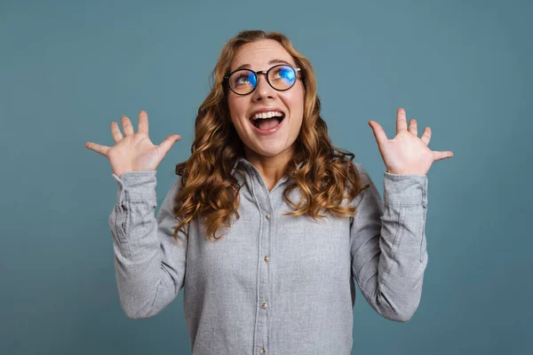 Spændt Pige Briller Smilende Mens Udgør Med Hænderne Isoleret Blå - Stock-foto