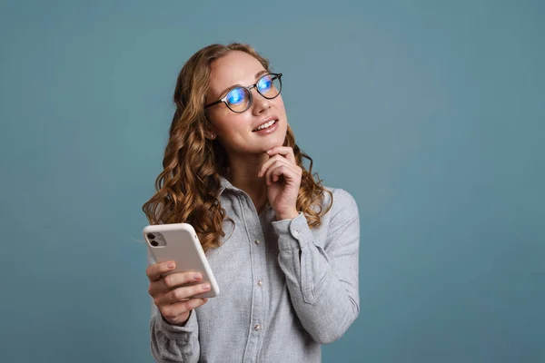 Vrolijk Mooi Jong Meisje Usig Mobiele Telefoon Geïsoleerd Blauwe Achtergrond — Stockfoto