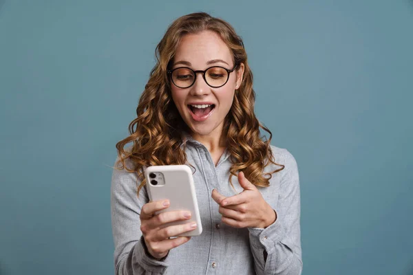 Vidám Csinos Fiatal Lány Usig Mobiltelefon Elszigetelt Kék Háttér Ujjal — Stock Fotó