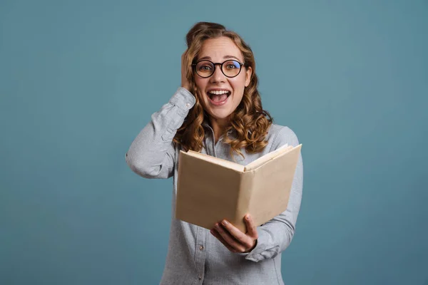 Aufgeregt Schönes Mädchen Brille Buch Lesen Isoliert Über Blauem Hintergrund — Stockfoto