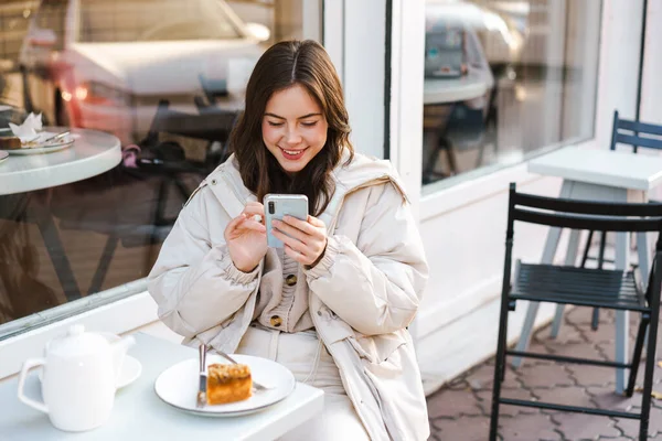 Улыбается Симпатичная Девушка Мобильным Телефоном Сидя Кафе Улице — стоковое фото