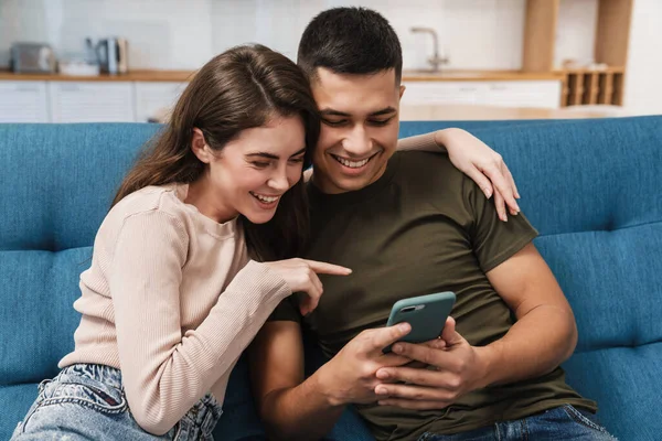 Sorrindo Casal Feliz Usando Telefone Celular Enquanto Sentado Sofá Casa — Fotografia de Stock