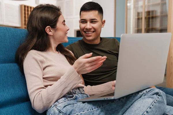 Uśmiechnięta Szczęśliwa Para Rozmowie Wideo Przez Laptop Siedząc Kanapie Domu — Zdjęcie stockowe