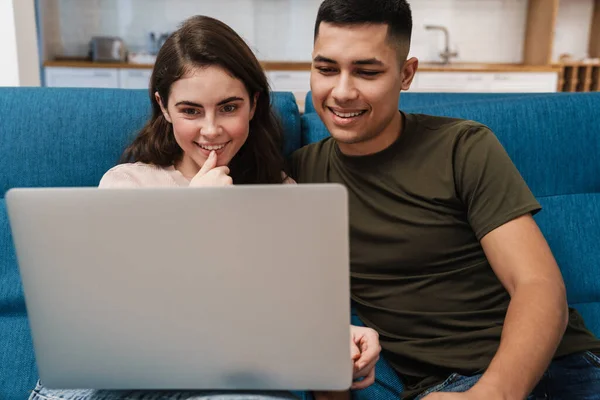 Uśmiechnięta Szczęśliwa Para Rozmowie Wideo Przez Laptop Siedząc Kanapie Domu — Zdjęcie stockowe
