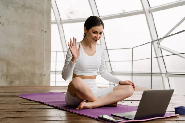 Ung Leende Kvinna Gestikulerar Och Använder Laptop Yogautövande Inomhus — Stockfoto