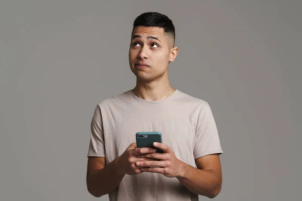 Brünetten Jungen Grübelnden Mann Blick Nach Oben Während Mit Handy — Stockfoto