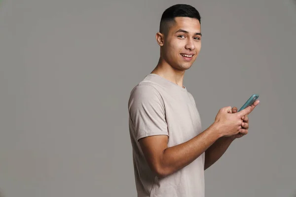 Chico Guapo Feliz Usando Teléfono Móvil Sonriendo Aislado Sobre Fondo — Foto de Stock