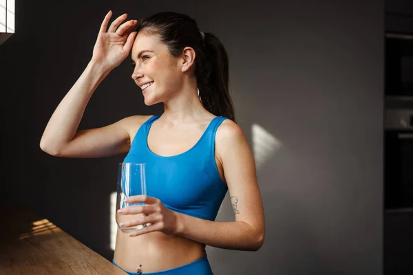 Gelukkig Jong Brunette Vrouw Sportkleding Holding Glas Staande Keuken — Stockfoto