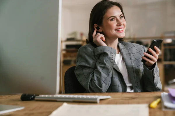 Smiling Woman Using Earphone Cellphone While Working Computer Office — Stock Photo, Image
